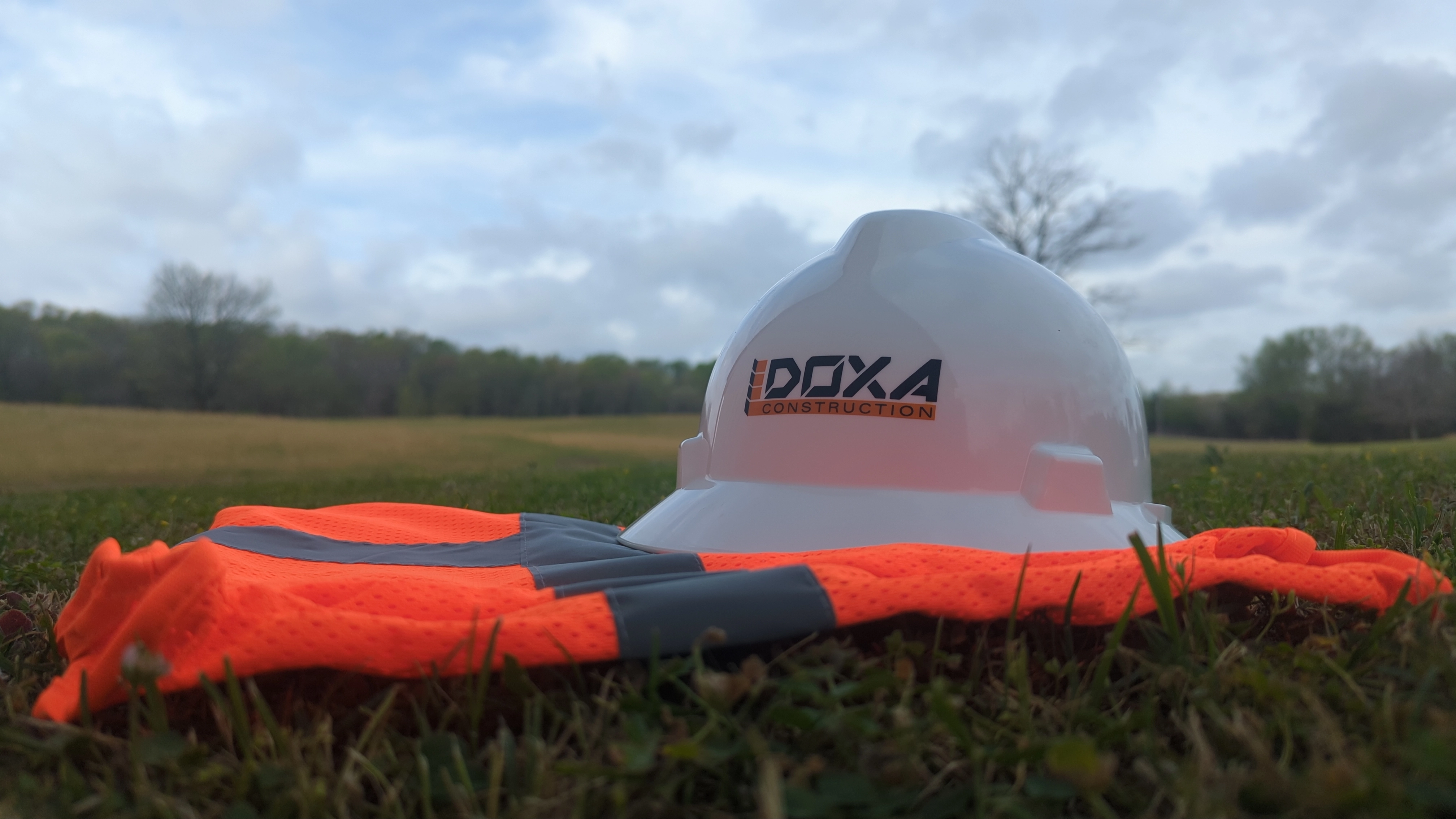 Hard hat and vest sitting in grass